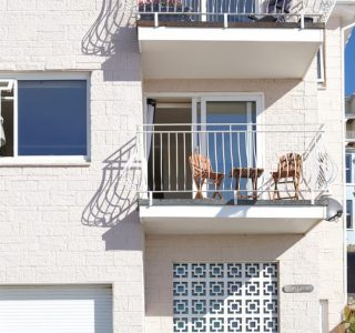 Exterior view of the balcony with doors leading to living area.