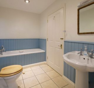 Bathroom complete with Sink with mirror above, toilet, and Bath
